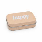 A three-quarter view of the closed beige tin with the white "huppy" logo on its lid, resting on a white background.