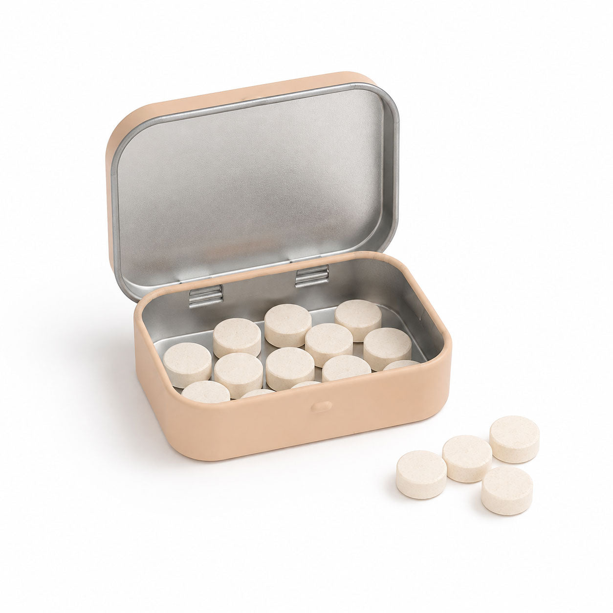 An open beige tin filled with off-white round tablets, with four additional tablets sitting on the white surface nearby.