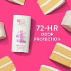 Native Piece of Cake deodorant on a bright pink backdrop surrounded by slices of frosted yellow cake.