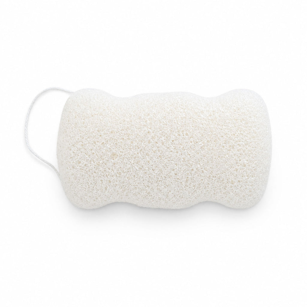 Flat, porous underside of a white konjac body sponge with an attached hanging cord, on a white surface.