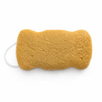 Flat side of a porous, mustard yellow konjac body sponge with a white hanging loop on a white background.