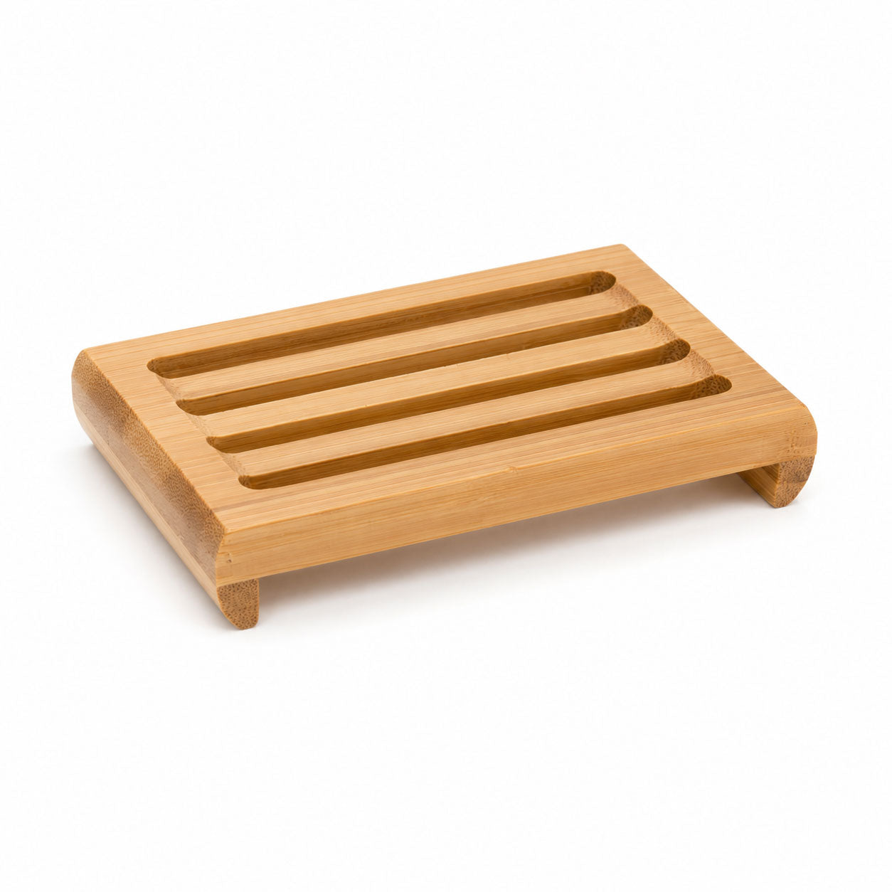 Angled side view of the slotted bamboo soap dish on a white surface, showing curved corner feet.