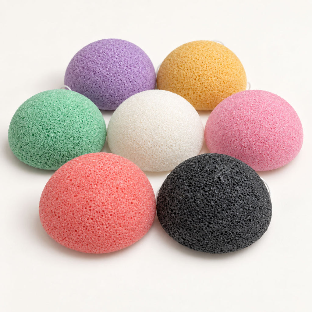 Side-angle view of seven colourful, dome-shaped porous sponges arranged together on a white background.