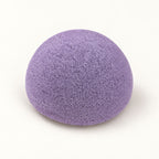 Dome-shaped purple konjac sponge on a plain white background.