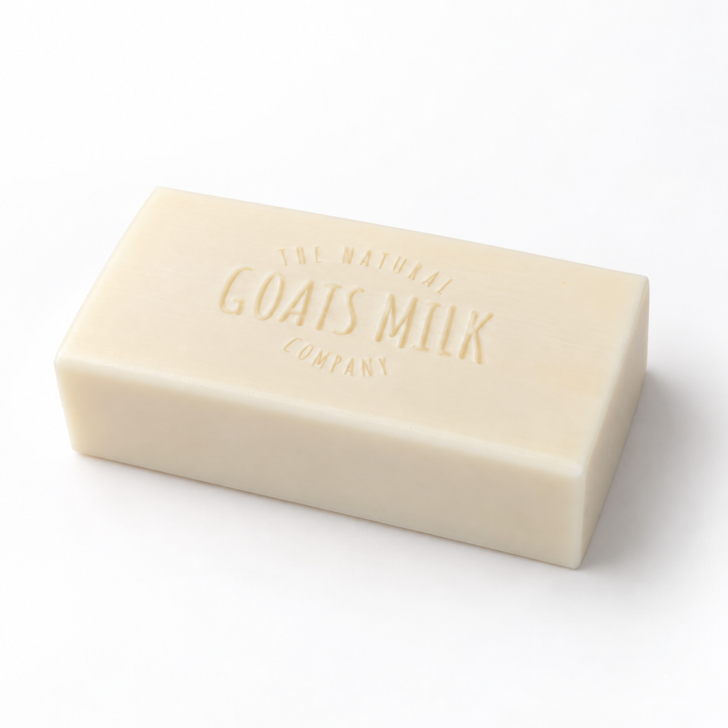 A rectangular bar of cream-colored goat's milk soap embossed with 'The Natural Goats Milk Company' on a clean white background.