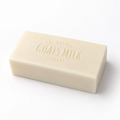 A rectangular bar of cream-colored goat's milk soap embossed with 'The Natural Goats Milk Company' on a clean white background.
