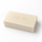 A rectangular bar of cream-colored goat's milk soap embossed with 'The Natural Goats Milk Company' on a clean white background.
