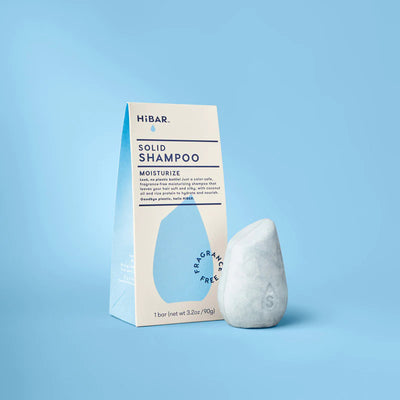 A light blue HiBAR Solid Shampoo box next to a greyish, teardrop-shaped shampoo bar on a light blue background.