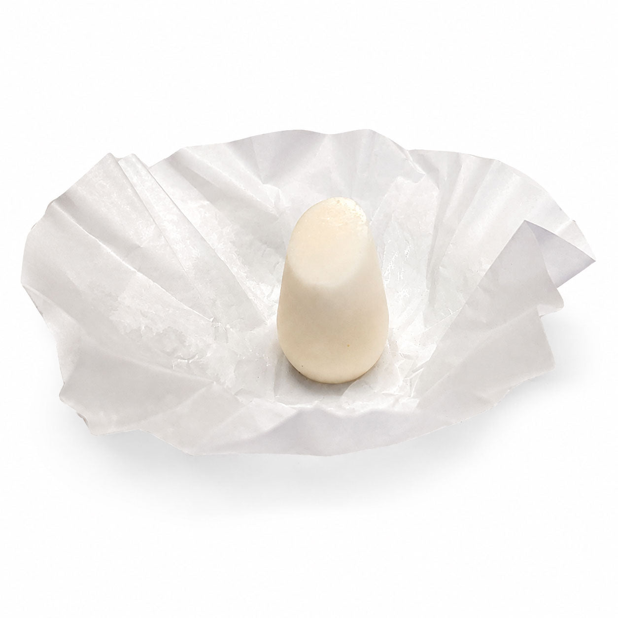 HiBAR Soothe conditioner bar, cream-coloured and unused, sitting on its opened white tissue paper wrap with no retail box