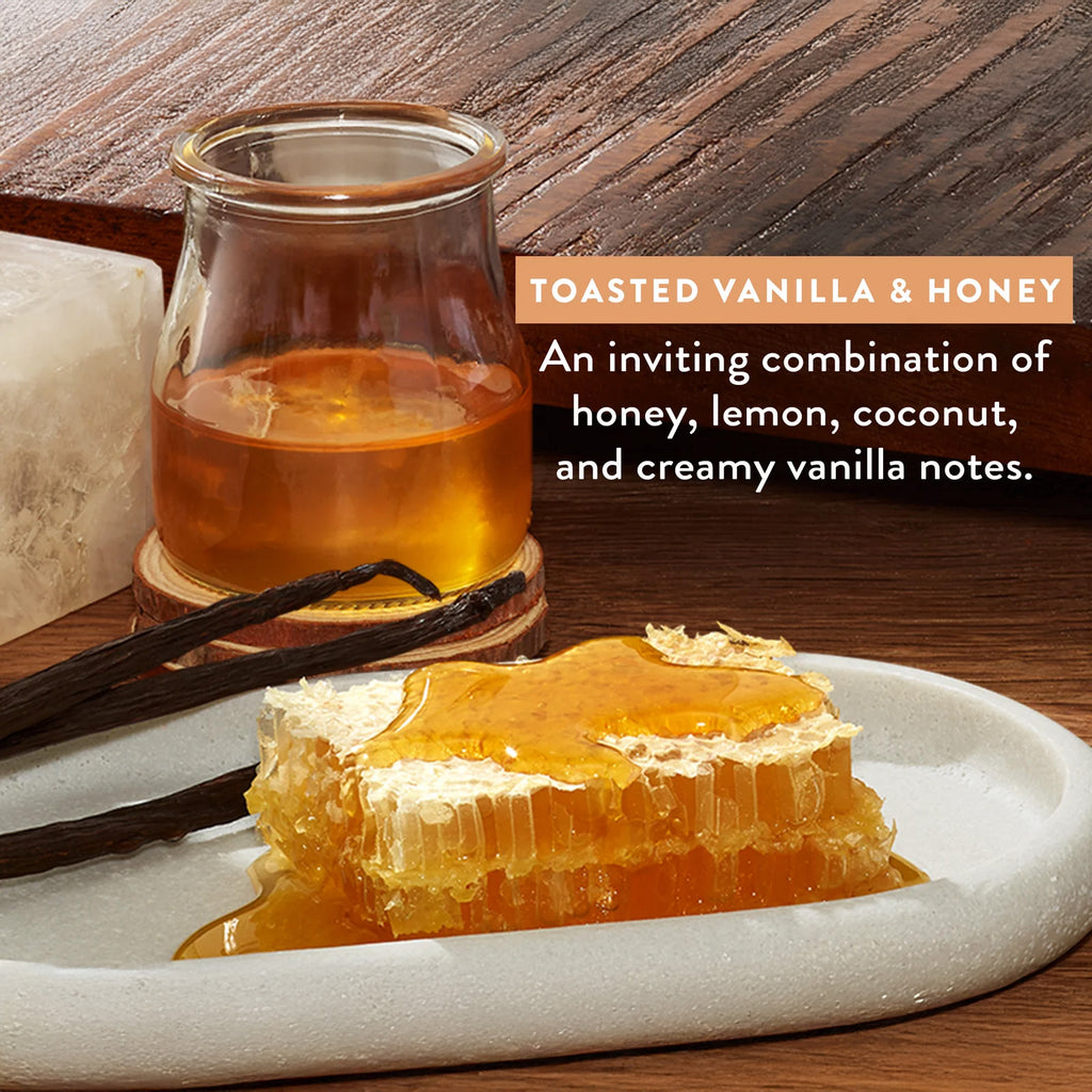 Glass of honey, honeycomb, and vanilla beans on a wooden surface with text describing the flavor profile.