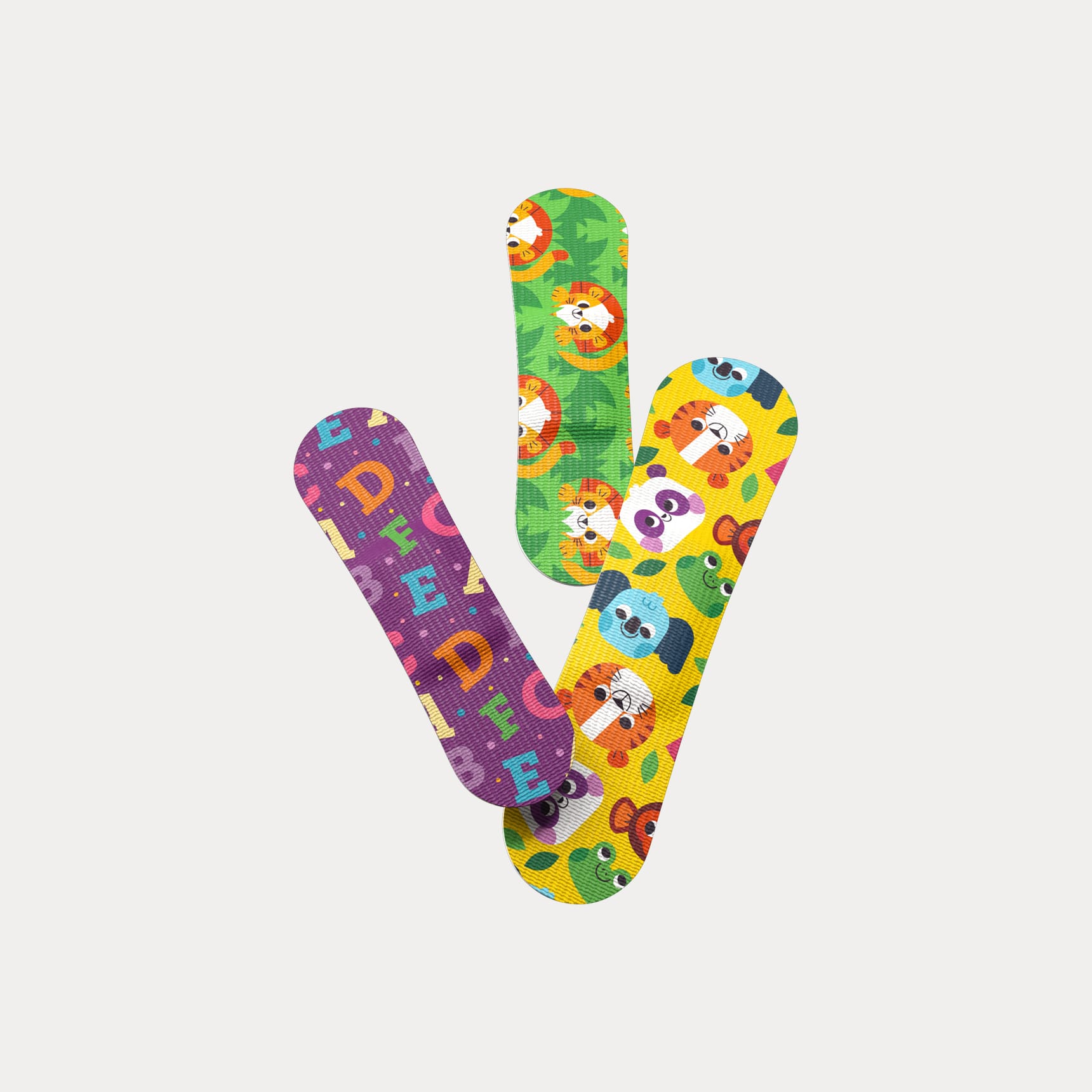 Three patterned flex fabric bandages in purple alphabet, green lion, and yellow animal face designs.