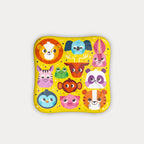 Top-down view of the square yellow tin lid covered in colourful cartoon zoo animal face illustrations.