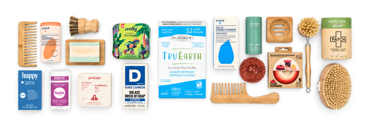 Sixteen everyday eco essentials laid out flat on white: bamboo comb, HiBAR natural deodorant, dish brush, soap on a bamboo dish, Welly fabric bandages, huppy mouthwash tablets, Humble deodorant, good juju conditioner bar, Duke Cannon soap, Tru Earth laundry strips, HiBAR solid conditioner, routine deodorant, bamboo soap dish, copper scourer, Food Huggers and a dry body brush