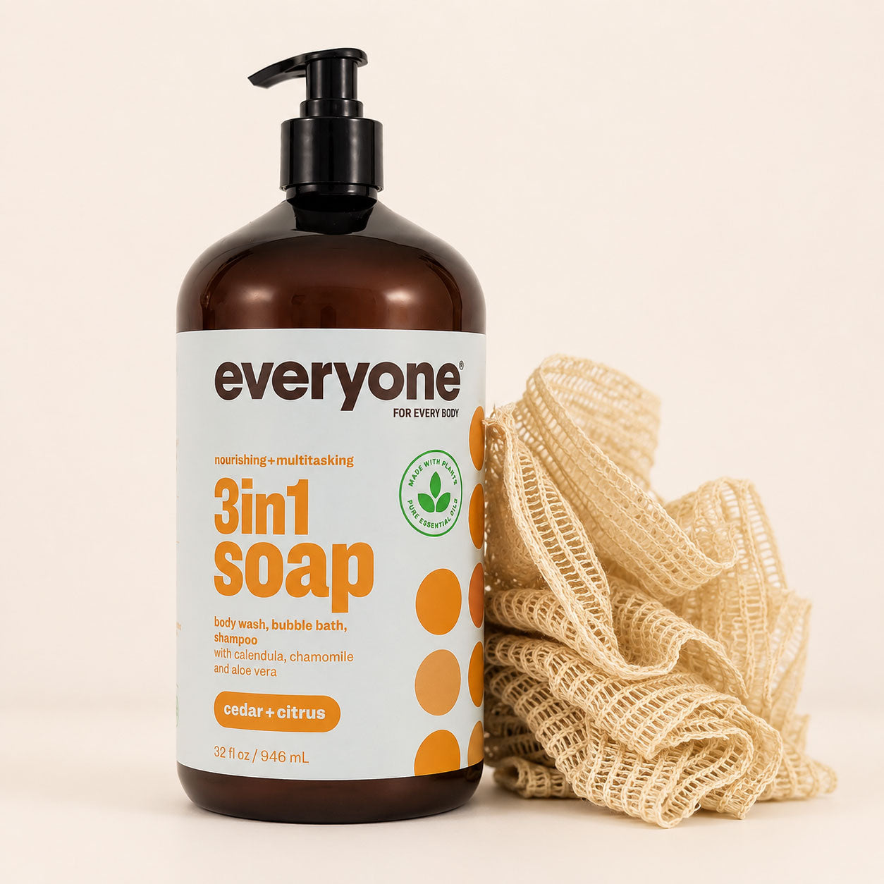 Natural ramie bath pouf with layered mesh construction and wooden bead toggle next to the 946 mL Everyone cedar and citrus soap bottle