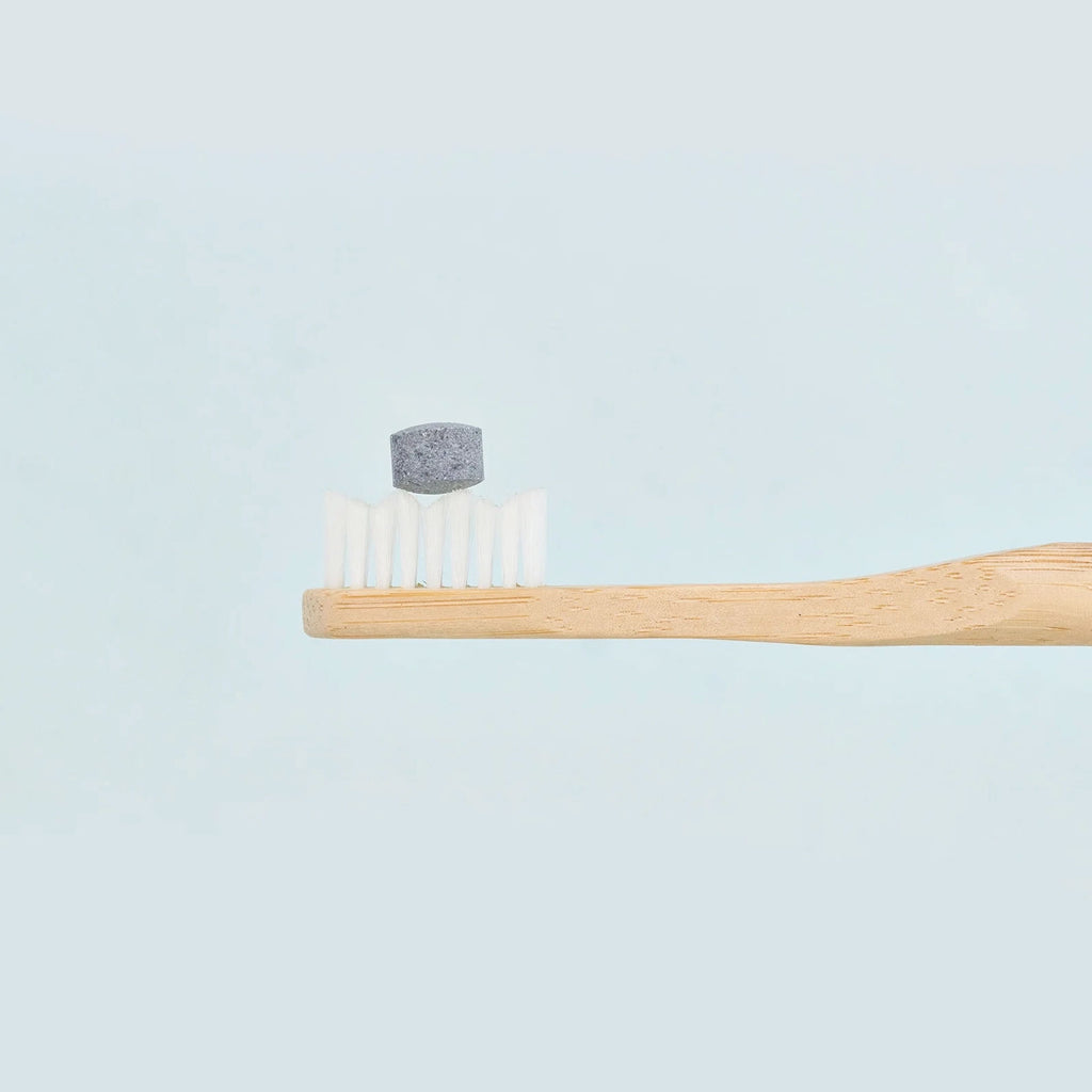 huppy toothpaste tablet on a toothbrush - charcoal mint