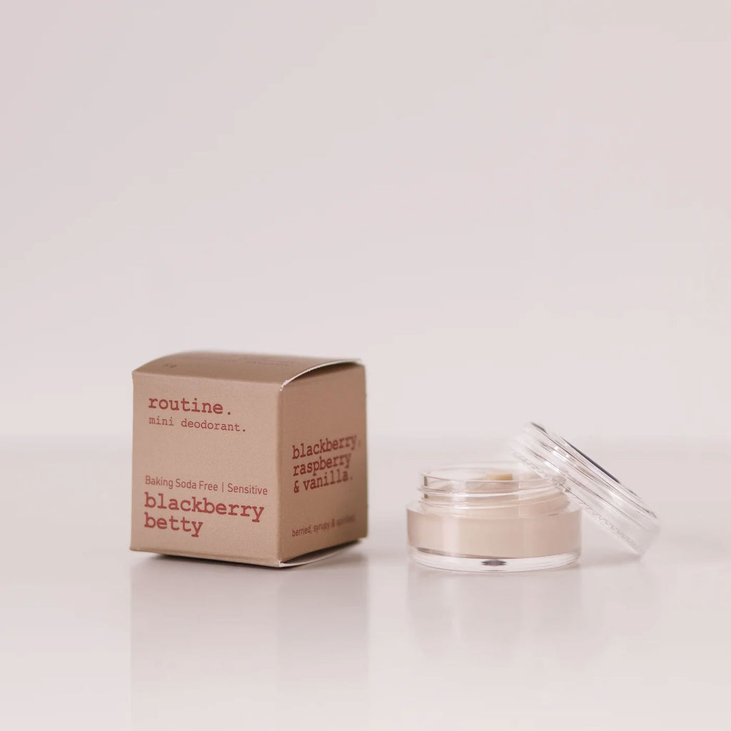 Routine Blackberry Betty baking soda free mini deodorant showing beige cardboard packaging with berry scent details next to open glass jar containing cream-coloured sensitive skin formula