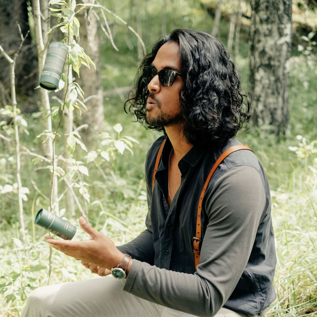A man outdoors holding Like A Boss Deodorant Stick showing on-the-go freshness in nature.
