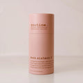 Routine Moon Sisters deodorant stick in blush‑pink paper tube with brown “moon sisters” branding, standing on a beige surface against a matching beige backdrop.