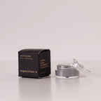 Routine Superstar mini deodorant showing black packaging with gold text next to open glass jar containing charcoal-grey natural deodorant with activated charcoal