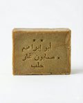 Front view of an olive-tan Aleppo soap bar stamped with Arabic text and two stars on a plain white background.
