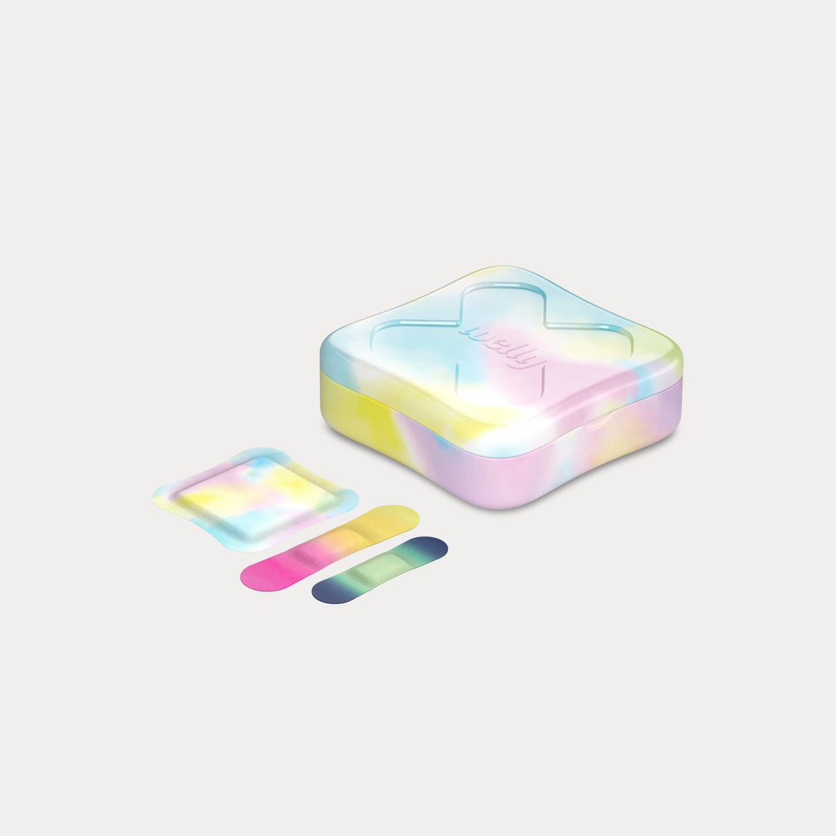 Closed tie-dye tin angled next to one wrapped square bandage and two loose, colorful gradient strip bandages.