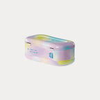 An angled side view of the closed Welly metal tin featuring a pastel tie-dye pattern on a grey background.