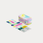 A closed tie-dye tin next to six colourful patterned bandages and two first aid ointment packets.