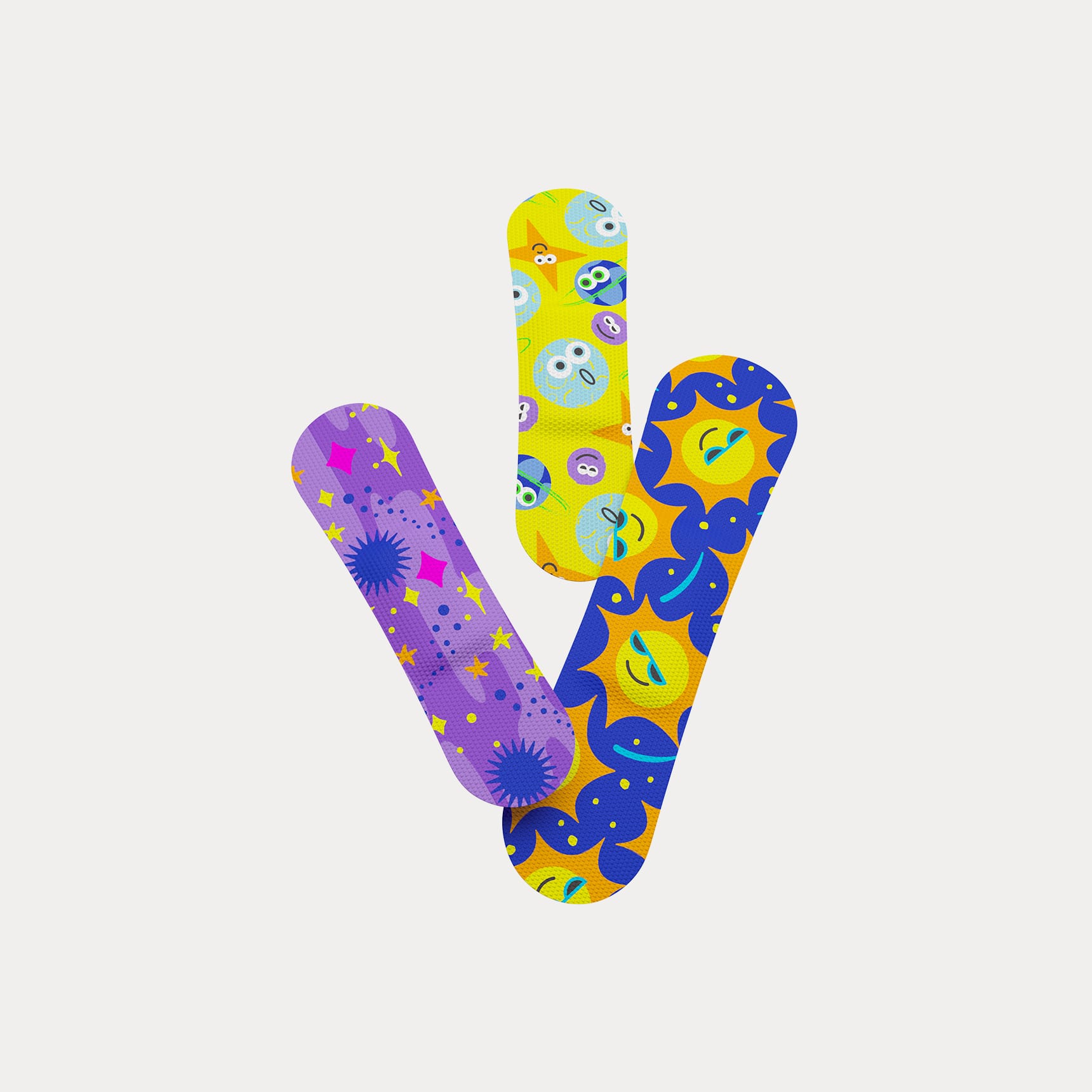 Trio of colourful Welly flex fabric bandages printed with smiling suns, stars, and celestial patterns.