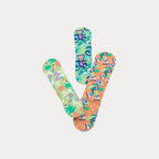 Three fabric bandages in tropical monkey, roller-skating turtle, and toucan patterns overlapping in a V-shape.