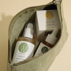 An open olive green Wildcraft pouch filled with skincare products, including a gel cleanser, face cream, and serum.