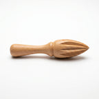 Hand-carved beechwood lemon squeezer with ridged conical head and turned handle on white background