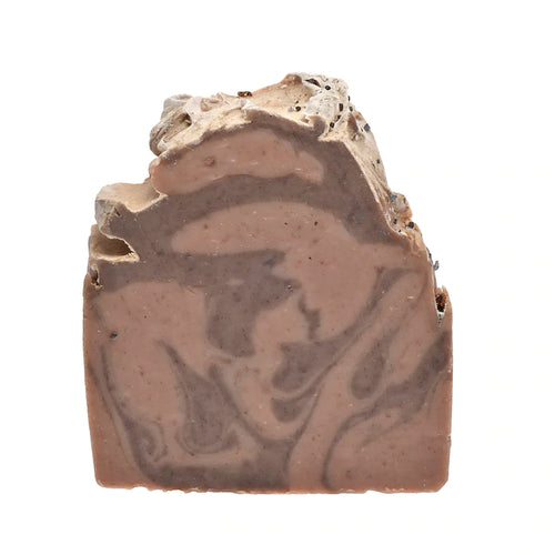 Unwrapped, the bar soap displays its full front face of marbled light brown and beige swirls under a textured top.